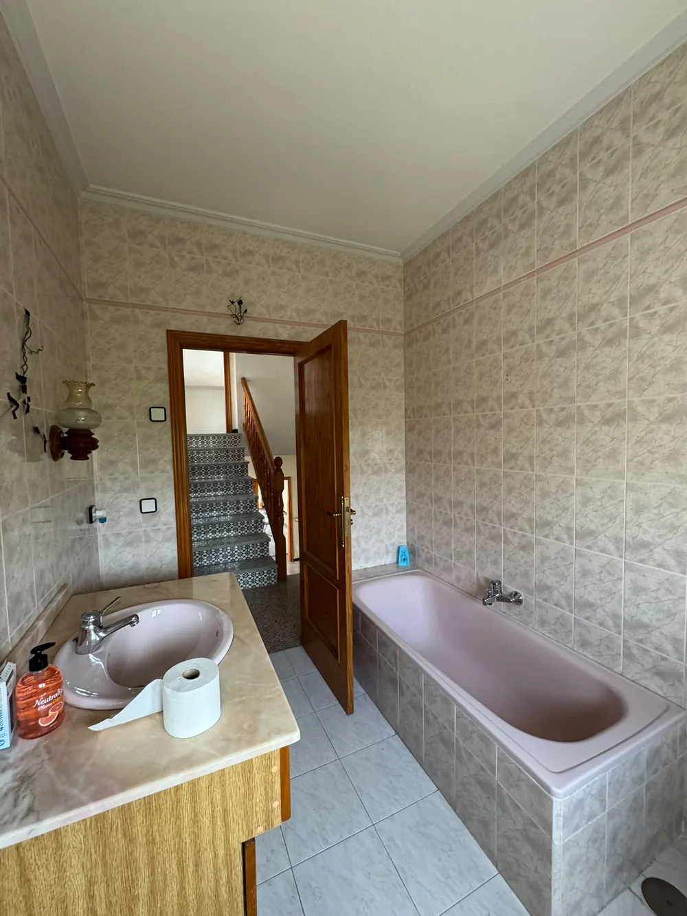 El baño antes de la reforma, con bañera rosa y azulejo antiguo