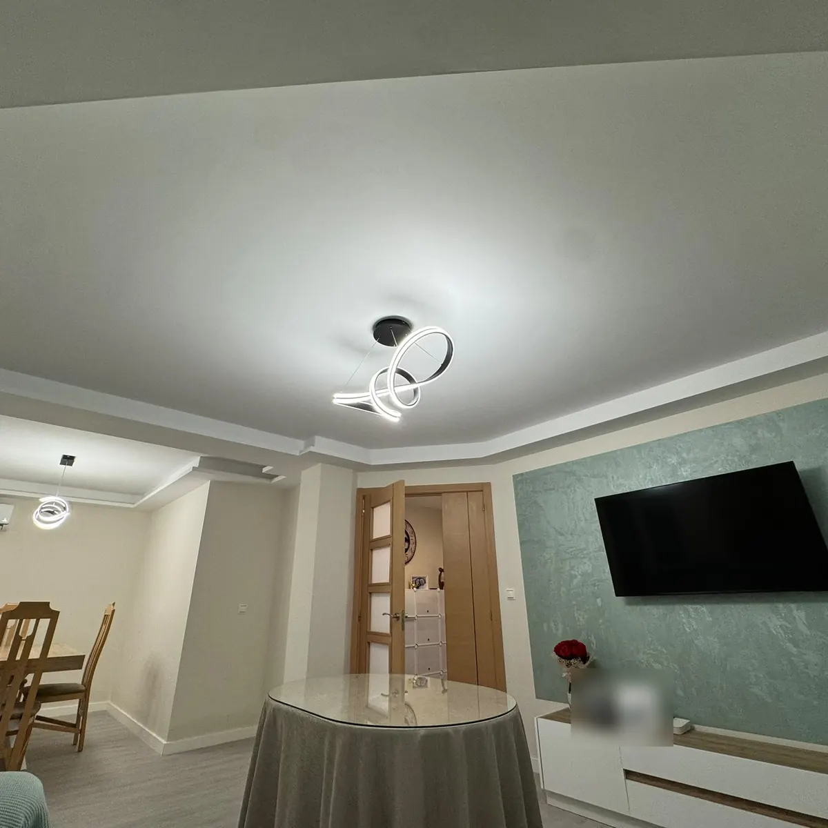 Salón reformado con techo nuevo iluminado y pared de estuco verde